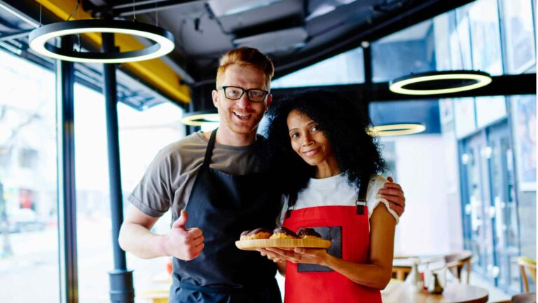 Deux restaurateurs souriants symbolisant le passage de relais lors de la vente.
