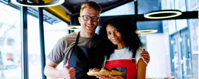 Deux restaurateurs souriants symbolisant le passage de relais lors de la vente.